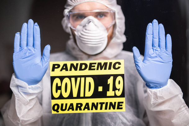 Muž v bílých kombinézách, s maskou a brýlemi na obličeji. Koronavirus, pandemie, covid-19, chřipka a karanténní koncepce. - Fotografie, Obrázek