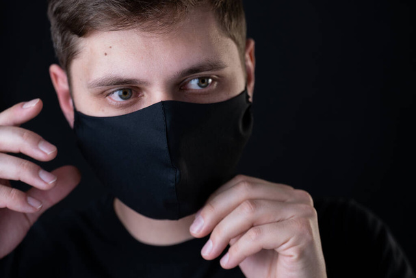 Man wearing black face mask. Pandemic coronavirus covid-19 quarantine period concept. - Φωτογραφία, εικόνα