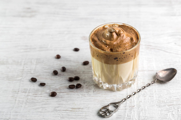 Iced Dalgona Coffee, fashionable fluffy creamy whipped coffee on a light coloured background. - Фото, зображення