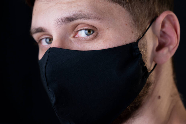 Man wearing black face mask. Pandemic coronavirus covid-19 quarantine period concept. - Photo, Image