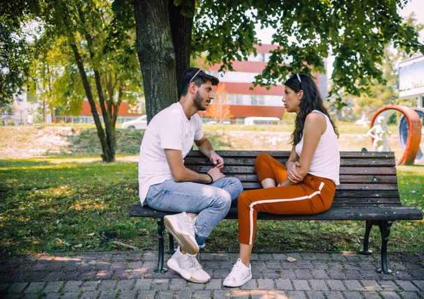 Young lovely couple or college students sit together in park. Leisure activity - Foto, Imagem