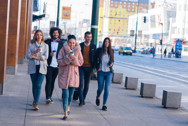 Ryhmä erilaisia työtovereita kävelemässä yhdessä, hymyilemässä ja ilmaisemassa - Valokuva, kuva