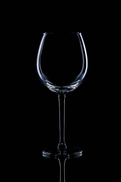 Wine glasses of different shapes and a bottle on a black background. A contour photo. - Foto, imagen