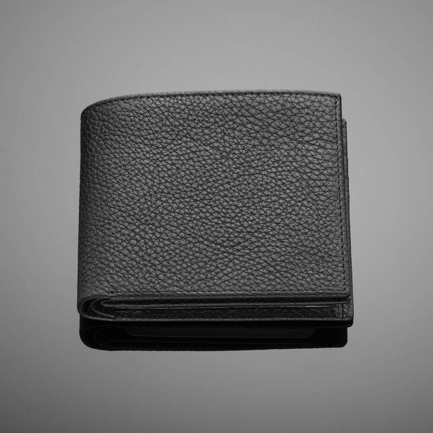 Fashionable designer leather men's wallet on a black background - Valokuva, kuva