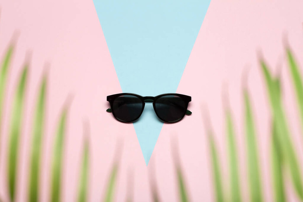 Fondo concepto de verano. Gafas de sol sobre un fondo soleado de colores. Concepto mínimo Flatlay
. - Foto, imagen