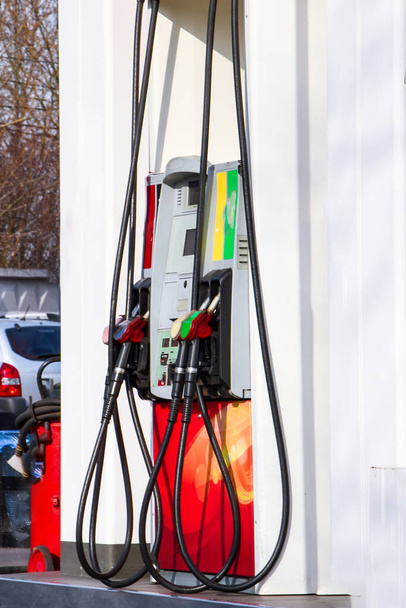 Handle fuel nozzle to refuel, fuel oil gasoline dispenser at petrol filling station,Fire extinguisher is installed for safety, Gas station in a service in warm sunset.Head fuel vehicle refueling facility - Photo, Image