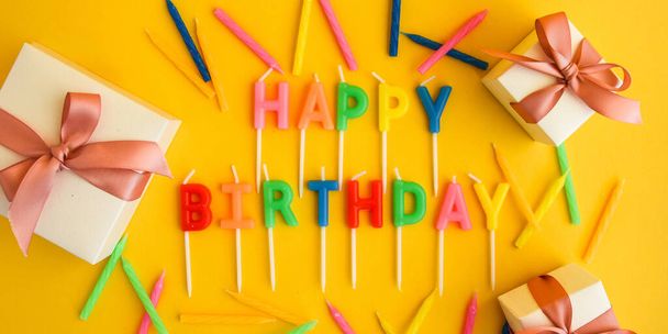 Happy Birthday Kerzen auf gelbem Hintergrund. Helle Farbe Tapete Kerzen mit Text Happy Birthday auf gelbem Hintergrund - Foto, Bild