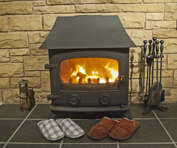Fechar a lareira com fogão de lareira multi queimador de combustível e par de chinelos
 - Foto, Imagem