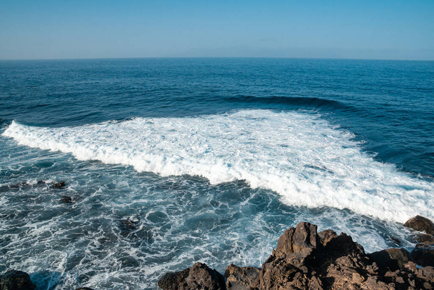 Large waves crash onto the granite boulders and rocks on atlantic ocean - Photo, image