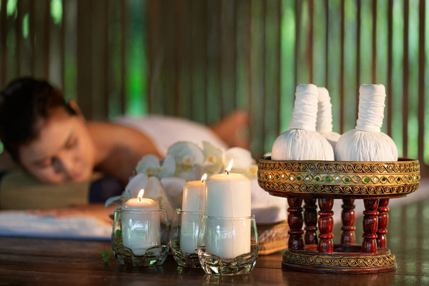 портрет молодой красивой тайской женщины в курортной обстановке.Красивая молодая женщина готовится к массажу с травяными мячами компресса в салоне терапии спа
. - Фото, изображение