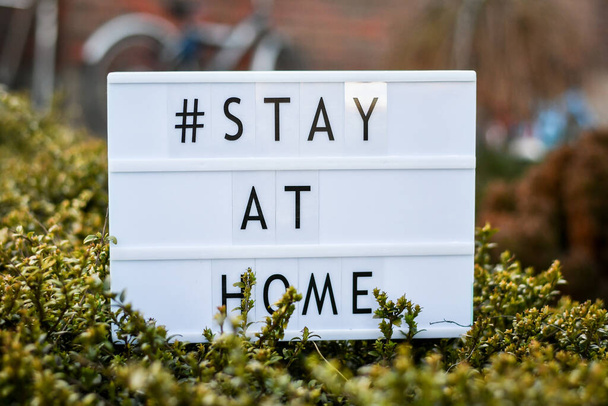Bleiben Sie zu Hause "Worte auf Leuchtkasten, steht in der Nähe des Eingangs des Hauses, Sicherheitskonzept. - Foto, Bild
