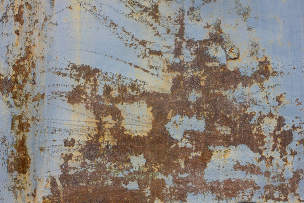 Vanha betoniseinä, jossa on sinisen maalin jäänteitä. Keltaisia ja ruskeita raitoja, tahroja. Nuhruinen pinta, pohja harmaa betoni. Päivänvalo
. - Valokuva, kuva