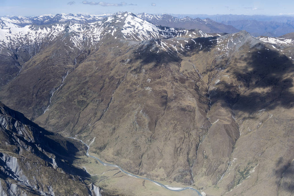 aerial, from a glider, of  inhabited valley of Poolnoon Burn river barren slopes, shot in bright spring light from west, Otago, South Island, New Zealand - Photo, Image