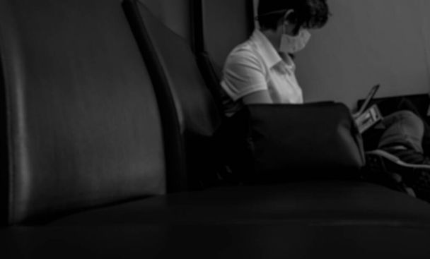Rozmazané ženy nosí chirurgickou masku a sedět na sedadle pomocí notebooku pro práci na veřejném místě čeká na vlak nebo letadlo letu. Sociální distancování. Koronavirus dopad na životní styl lidí.  - Fotografie, Obrázek