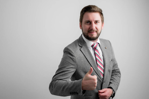 Портрет бизнесмена в деловой одежде, изображающий жесты изолированные на сером фоне с зоной рекламы копировального пространства
 - Фото, изображение