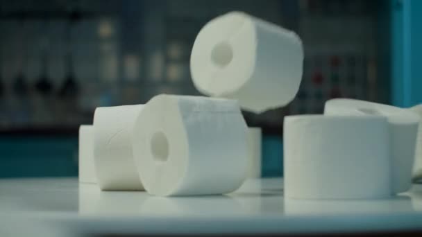 Lot of toilet paper rolls falling on table at home kitchen during coronavirus COVID-19 quarantine. Funny concept of toilet paper deficit.  - Záběry, video