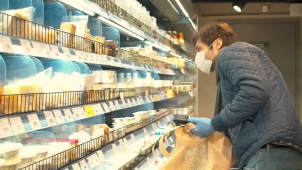 Muž vybírající mléčné výrobky v supermarketu - Záběry, video