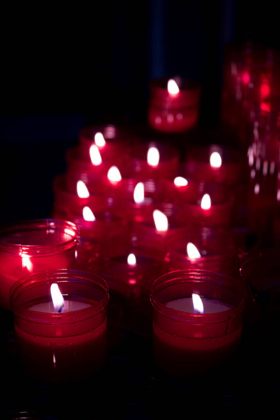 Viele brennende Kerzen mit roter Plastikhülle. Kein Volk - Foto, Bild