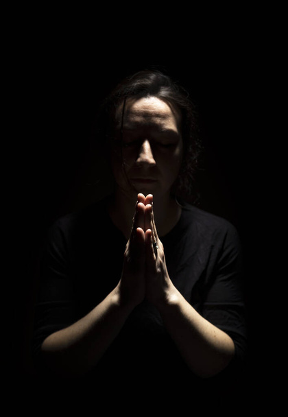 Woman standing in prayer in dark background. Silhouette of Woman standing in prayer - Φωτογραφία, εικόνα