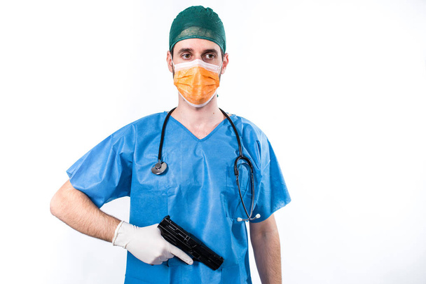 Young doctor holding gun isolated on white background - 写真・画像