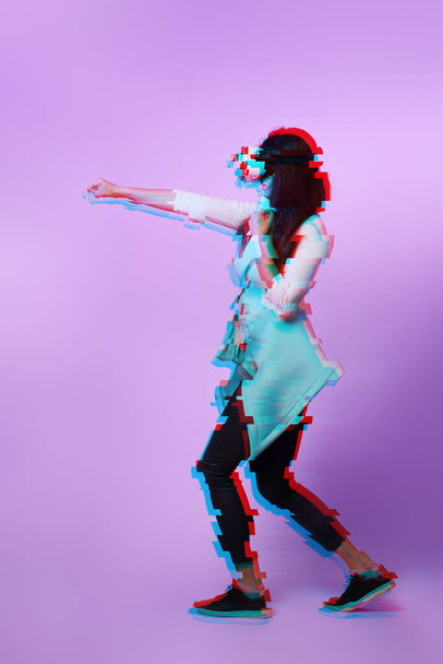 Woman is using virtual reality headset. Image with glitch effect. - Foto, Bild