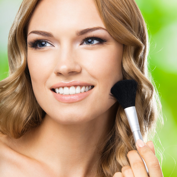 Smiling woman with make up brush, outdoor - Foto, immagini