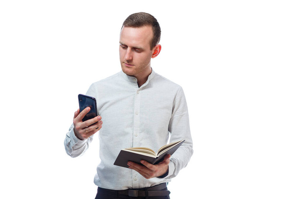 Homem homem de negócios, professor, mentor examina entradas em seu diário e falando em um telefone celular. Isolado sobre fundo branco
 - Foto, Imagem