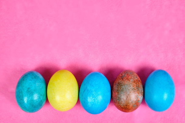 Sokszínű, festett húsvéti tojás rózsaszín alapon. - Fotó, kép