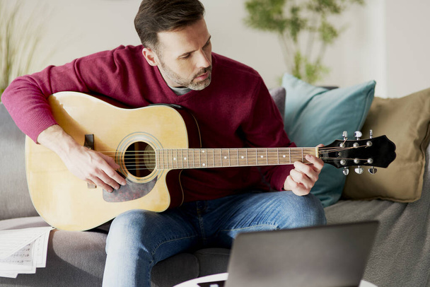Człowiek w średnim wieku gra na gitarze akustycznej - Zdjęcie, obraz