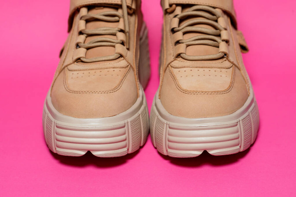 hnědé kožené dámské boty s vysokými podrážkami na růžovém pozadí. módní obuv - Fotografie, Obrázek