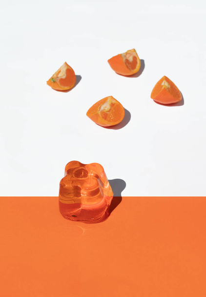 Oranssi hyytelö valkoisella ja oranssilla taustalla appelsiinit, ylhäältä
 - Valokuva, kuva