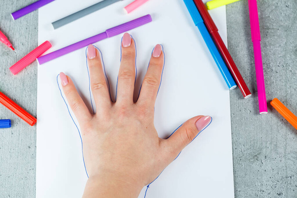 Girl draws with multi-colored felt-tip pens on white paper - Foto, Bild
