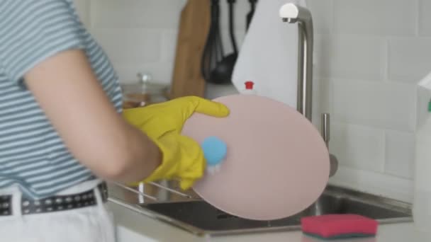 Vrouw handen spoelen plaat bij de gootsteen - het doen van de klusjes thuis met spons afwasmiddel. Vaatwas routine, statische camera. - Video