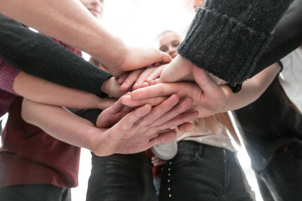 grupo de jóvenes diversos que construyen una torre de sus manos
 - Foto, Imagen