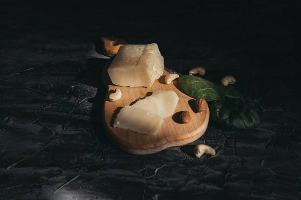 木製の雨の上でナッツとパルメザンチーズをスライス - 写真・画像