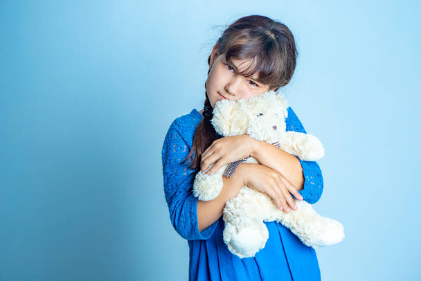 indoor portrait of young child girl with teddy bear, isoalted studio shot - Фото, изображение