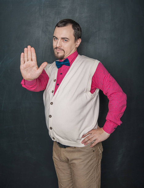 Funny teacher or business man with stop gesture on blackboard background - 写真・画像