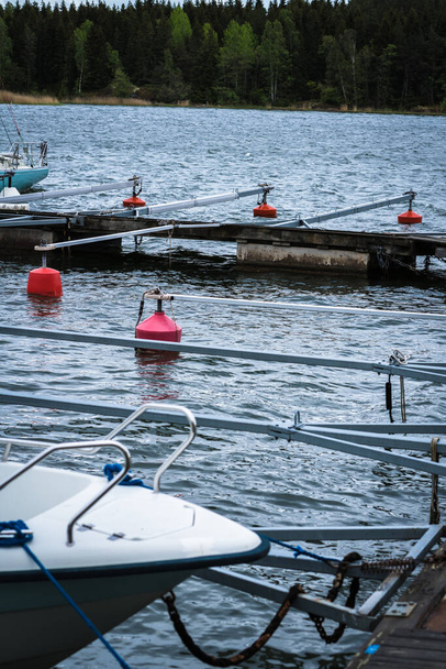 Barras de ancoragem de barco na água em bóias vermelhas, dia de verão, floresta na margem oposta
 - Foto, Imagem