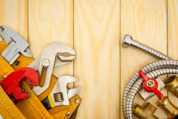 Les outils de plomberie dans le sac et les tuyaux sur les planches en bois sont utilisés pour remplacer ou réparer
 - Photo, image
