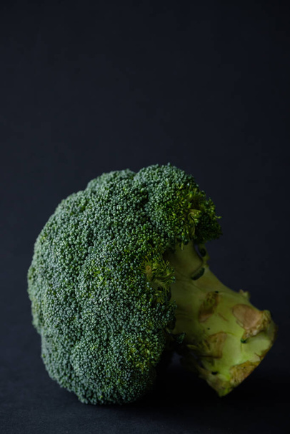 Green broccoli on a black background. Fresh greens - Foto, imagen