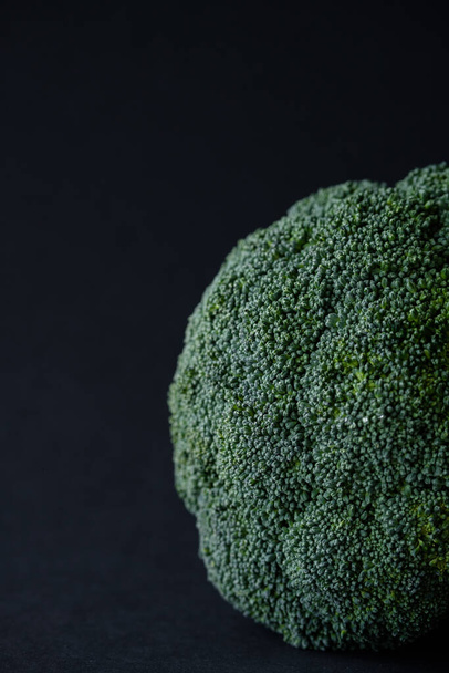 Green broccoli on a black background. Fresh greens - Фото, зображення