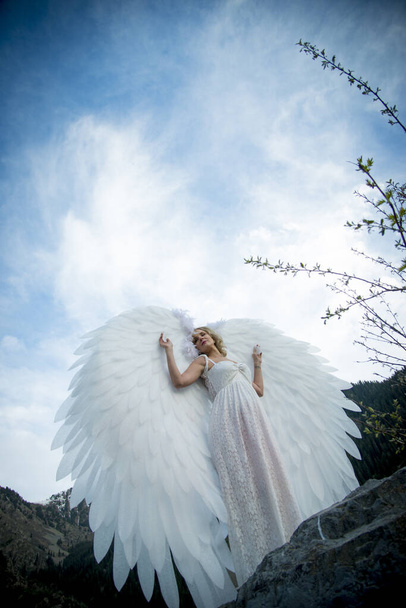 beautiful bride with angel wings posing in nature  - Photo, Image
