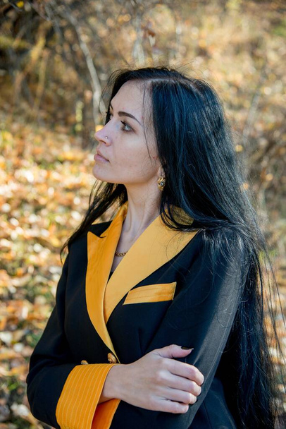 beautiful brunette posing in black and yellow coat  - Foto, afbeelding