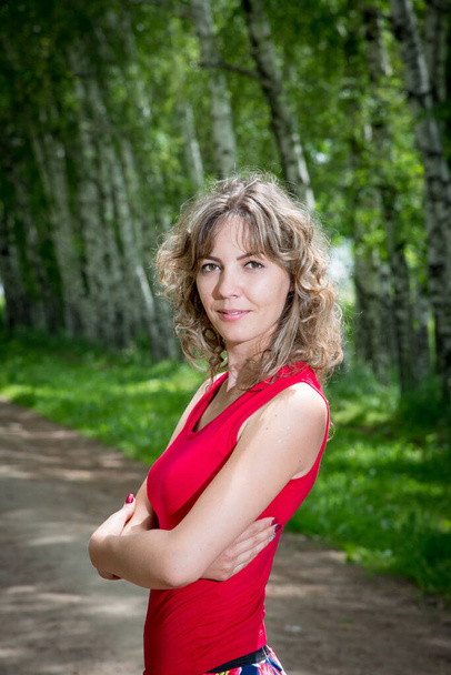 young beautiful woman posing on alley with birch trees - Zdjęcie, obraz