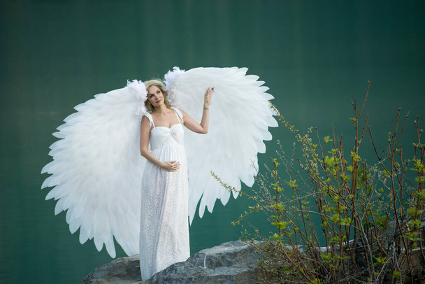 beautiful bride with angel wings posing in nature  - Valokuva, kuva