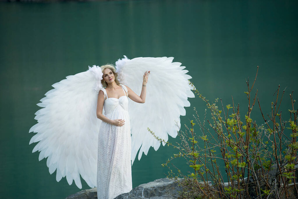 beautiful bride with angel wings posing in nature  - Photo, image