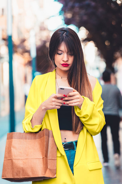 mujer de compras y mirando el teléfono inteligente en la calle
 - Foto, Imagen