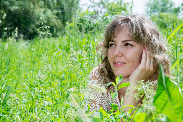 krásná žena pózující na poli se zelenou trávou  - Fotografie, Obrázek