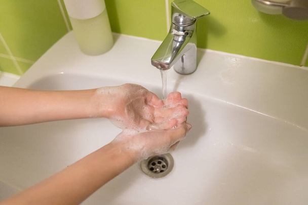 男の子は、コロナウイルスの予防、コロナウイルスの拡散を停止する衛生のための石鹸で手をこすり洗っている - 写真・画像
