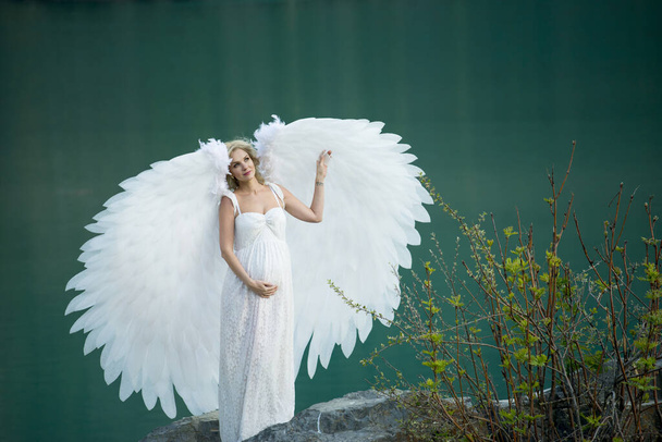 beautiful bride with angel wings posing in nature  - Photo, image